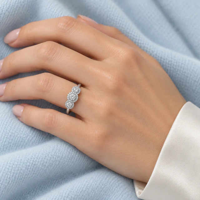 Jennifer Trilogy Ring worn on the ring finger against pale blue fabric